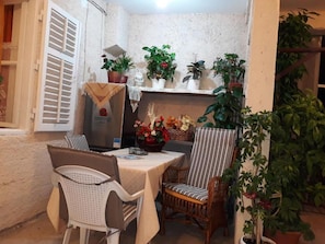 A cozy outdoor seating area with a table, chairs, and potted plants. - Holiday Home With Parking and 2 Rooms (Dubrovnik)