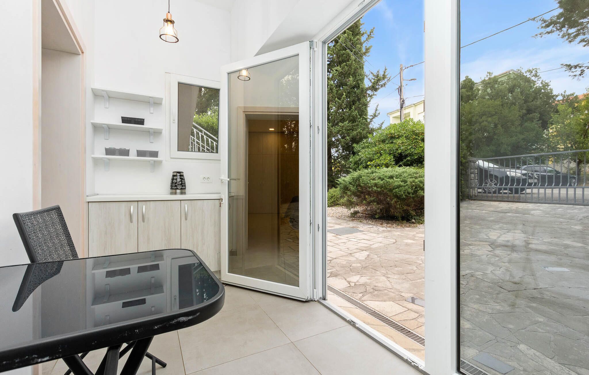 Une cuisine moderne avec une porte vitrée donnant sur un patio.