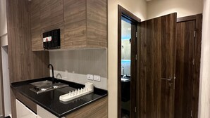 Una cocina moderna con isla integrada, muebles de madera oscura y encimera negra.