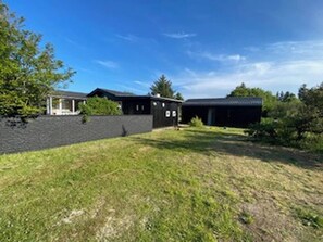 A residential property with a paved driveway, a covered porch, and a grassy yard. - Panoramic sea View Direct Sandy Beach Skagen South (Aalbaek)