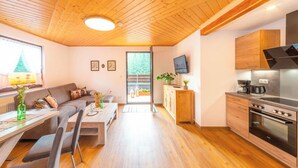 Eine moderne Küche mit eingebautem Ofen und einem Essbereich mit Holztisch und Stühlen.