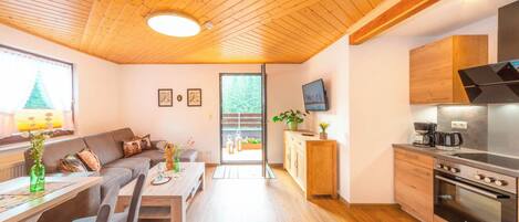 A modern kitchen with a built-in oven and a dining area with a wooden table and chairs.