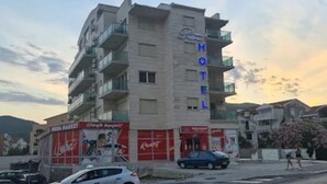 Ein Hotel mit mehreren Etagen, Balkonen und einer Coca-Cola-Werbeanzeige an der Fassade.