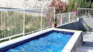 A swimming pool with a white fence, surrounded by greenery and flowers. - Villa Nika-five Bedroom Villa With Pool (Zupa dubrovacka)