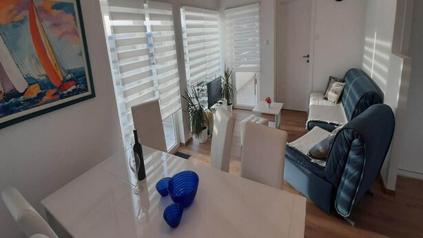 A living room with a sofa, a coffee table, and a painting on the wall. - Villa Nika-five Bedroom Villa With Pool (Zupa dubrovacka)