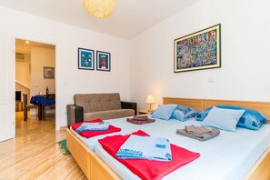 Ein Hotelzimmer mit Bett, einer Sitzecke, einem Essbereich und Bildern an den Wänden.