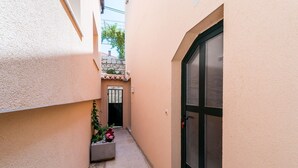 A narrow alleyway with a door on the right and a window on the left. - Apartments Casa Vanna - One Bedroom Apartment (Dubrovnik)