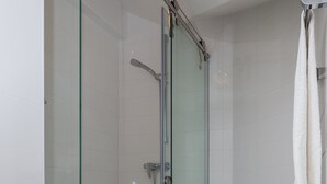 A glass-enclosed shower with a white tiled wall and a black floor. - Villa Celenca - Superior Two Bedroom Apartment With Terrace and Sea View - A5 (Dubrovnik)