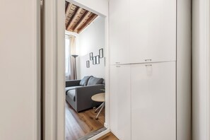 Ein modernes Interieur mit einem grauen Sofa, einem kleinen runden Tisch und einem weißen Kleiderschrank.