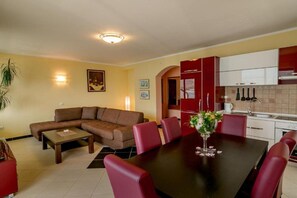 Ein Wohnzimmer mit einer Couch, einem Couchtisch und einem Essbereich mit Tisch und Stühlen.