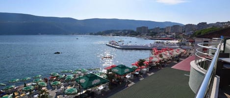 A waterfront promenade with outdoor seating and a view of the sea.