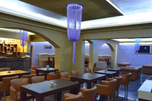 A restaurant with tables and chairs, a bar area, and a seating area with couches. - Amor Residence - Studio Apartment with Terrace and Sea View (4 ) (Herceg Novi)