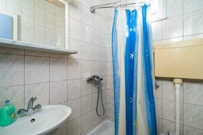 Ein Badezimmer mit Dusche, Waschbecken und Toilette.