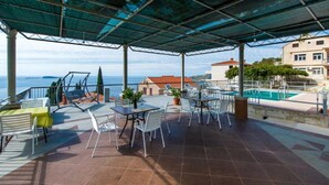 A covered outdoor area with a pool, seating, and a view of the sea. - Apartments Klis -studio Apartment With Terrace - 2 (Zupa dubrovacka)