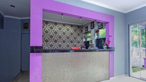 A reception area with a counter, a patterned wall, and a window with a view.