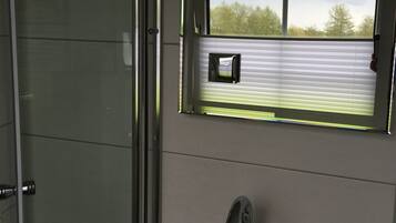 Ein Badezimmer mit Dusche, einem Fenster mit Jalousien, einem Waschbecken mit Wasserhahn und einer Seifenspender.