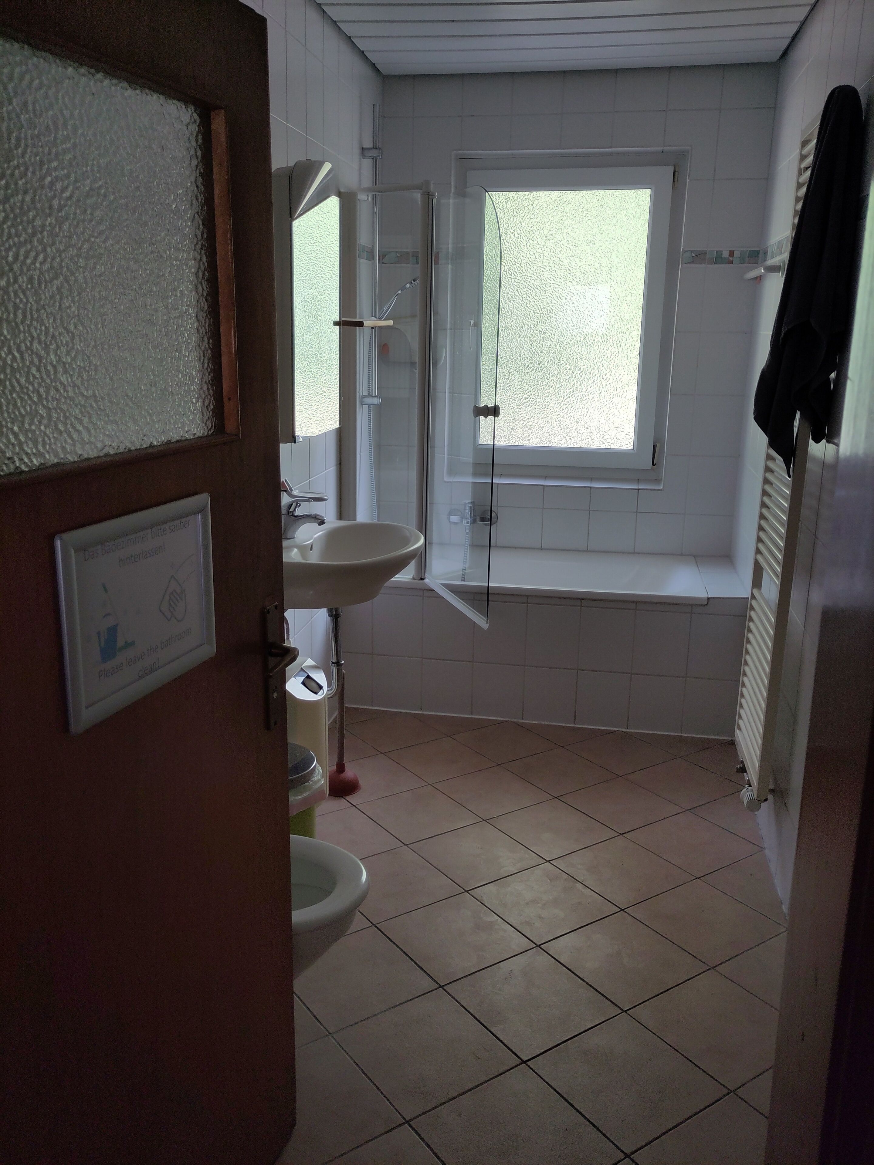 A bathroom with a toilet, sink, and shower area.