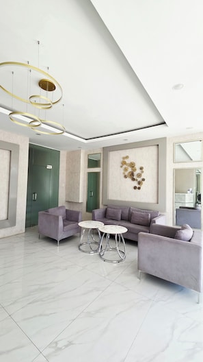 A modern living room with a sofa set, a coffee table, and a unique wall art piece. - Relax in a Cozy & Comfortable Studio across Robinsons Galleria (Cebu City)