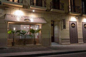 A hotel entrance with a sign reading 'REINA VICTORIA,' potted plants, and a gated entrance. - Premium double apartment (Alicante)