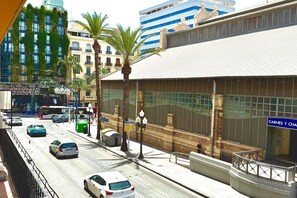 A city street with cars, a bus, and a pedestrian. - Premium double apartment (Alicante)