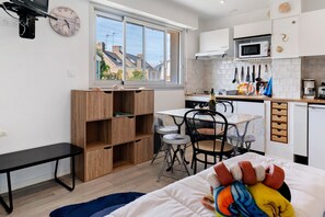 A compact kitchen with a dining area, a small table, and a bench.