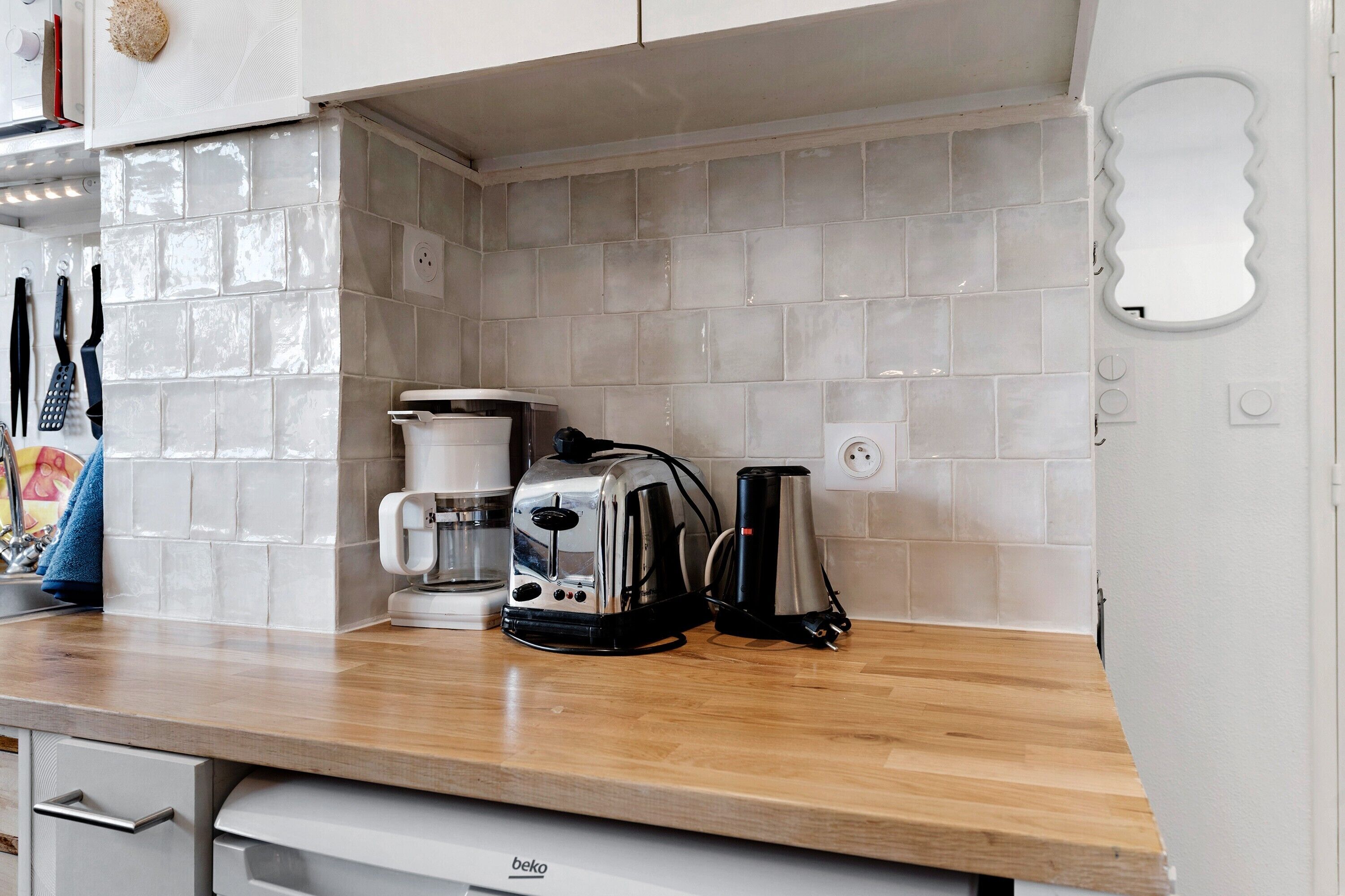 Une cuisine équipée d’un plan de travail en bois, d’une machine à café, d’un grille-pain et d’une bouilloire.