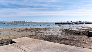 Eine Küstenlandschaft mit Booten auf dem Wasser und einem felsigen Strand.