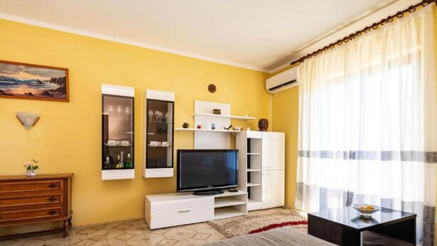A living room with a television, white cabinets, a sofa, and a dining table. - Two Bedroom Apartment With Terrace (Preko)