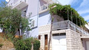 A multi-story building with balconies, a satellite dish, and a stone facade. - Bertie's Lodge - Two Bedroom Apartment With Terrace and Sea View (Smokvica)