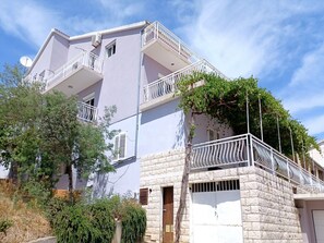 A multi-story building with balconies, a satellite dish, and a stone facade. - Bertie's Lodge - Two Bedroom Apartment With Terrace and Sea View (Smokvica)