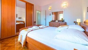 Una camera d'albergo con un letto grande, un'armadiatura in legno e una cassettiera.
