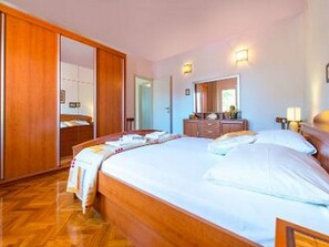 Ein Hotelzimmer mit einem großen Bett, einem Holzschrank und einem Schminktisch.
