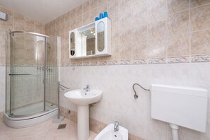 Ein Badezimmer mit Duschkabine, Waschbecken und Toilette.