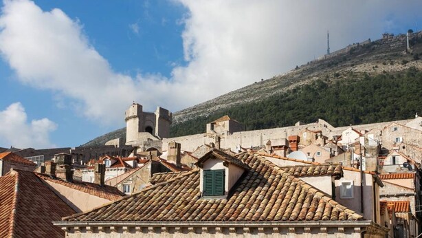 A historic town with stone buildings, a prominent tower, and a hill in the background. - Guest House Lumin - Twin Room With City View (Dubrovnik)