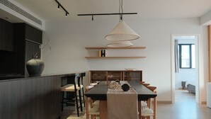 Una cucina moderna con isola centrale, illuminazione a sospensione e scaffalature integrate.