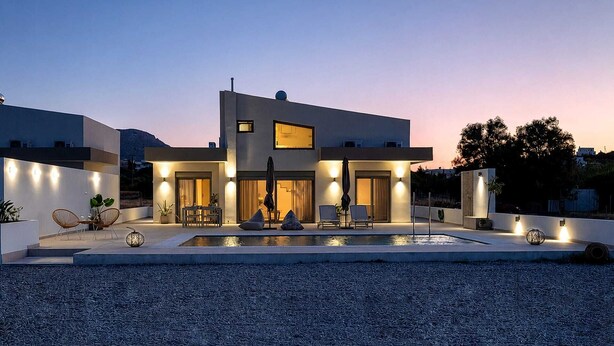 A modern two-story house with a swimming pool, outdoor seating, and a well-lit entrance. - Azzurro Luxury Villa 2 (Rhodes)