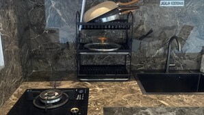 A kitchen with a black stove, a sink, and a wooden cabinet. - 2 Bed Room Villa with Private Pool (Singaraja)