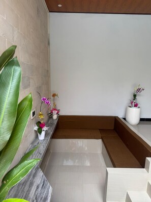 Un interior moderno con encimera de mármol, plantas en macetas y un banco empotrado.