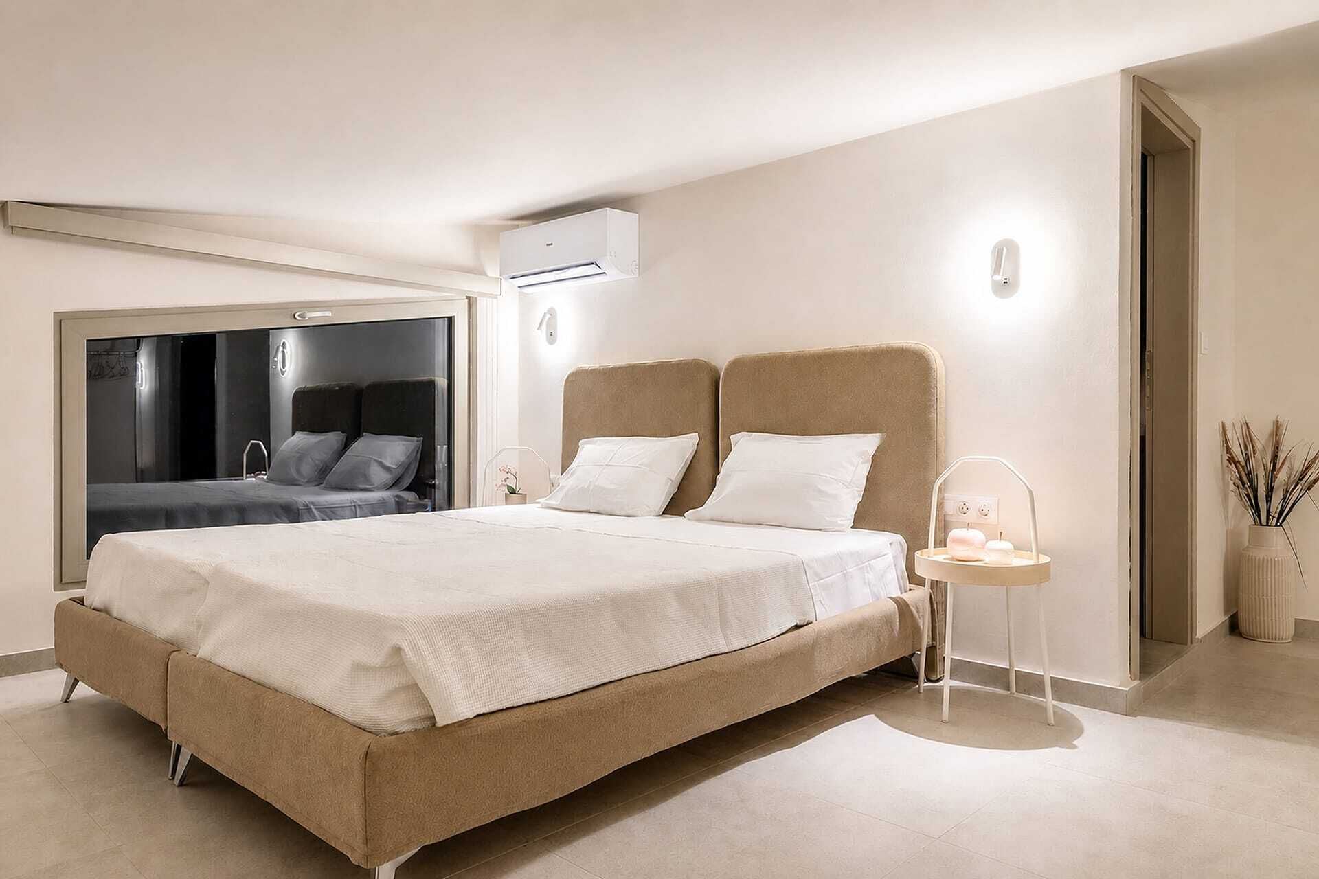 Une chambre moderne avec un grand lit, une table de chevet avec une lampe et un miroir.