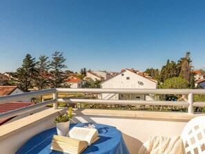 A balcony with a table, a book, and a potted plant. - Apartments Anamarija - One Bedroom Apartment With Balcony - 4 (Privlaka)