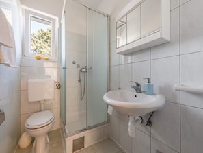 A bathroom with a toilet, a glass-enclosed shower, and a sink. - Apartments Anamarija - One Bedroom Apartment With Balcony - 4 (Privlaka)