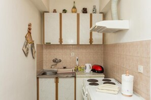 A compact kitchen with a sink, stove, and cabinets. - Apartment Stella Polaris - Studio Apartment A2 (Dubrovnik)