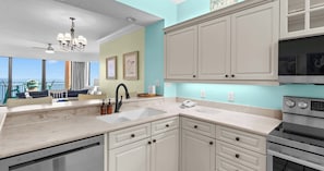 A modern kitchen with white cabinets, a built-in oven, and a dishwasher. - Seaside Sanctuary Beachfront (Orange Beach)