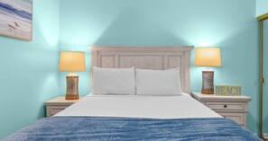 Ein Schlafzimmer mit einem Bett, zwei Nachttischen, zwei Lampen und einem Wandbild.