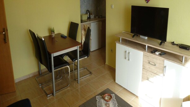 A compact living space with a dining area, kitchenette, and a television. - Apartments Smokvica - Superior One Bed /apt (Starigrad)