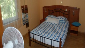 A bedroom with a bed, a nightstand, a mirror, and a fan. - Apartments Smokvica - Superior One Bed /apt (Starigrad)