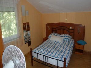A bedroom with a bed, a nightstand, a mirror, and a fan. - Apartments Smokvica - Superior One Bed /apt (Starigrad)