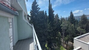 A balcony with a view of tall trees and a clear sky. - Apartments Smokvica - Superior One Bed /apt (Starigrad)