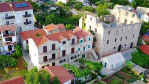 A residential area with multi-story buildings, some with balconies, and a mix of paved and unpaved ground. - Apartments Paloc - One-bedroom Apartment With Balcony (Bol)