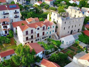 A residential area with multi-story buildings, some with balconies, and a mix of paved and unpaved ground. - Apartments Paloc - One-bedroom Apartment With Balcony (Bol)